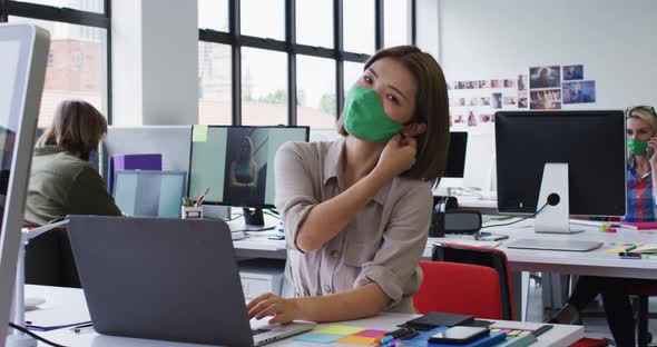 Portrait of asian woman removing face mask at modern office