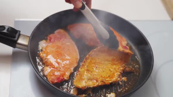 Unrecognizable cook frying tenderloin marinated in pan