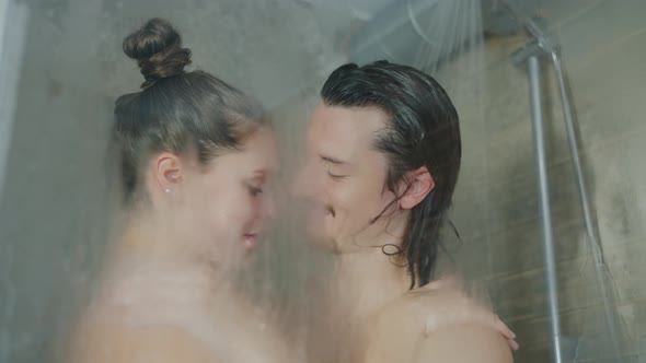 Beautiful Couple Kissing While Washing in Shower Together in Modern Hotel