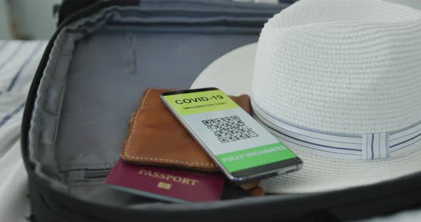 African american senior woman packing covid vaccine passport into suitcase