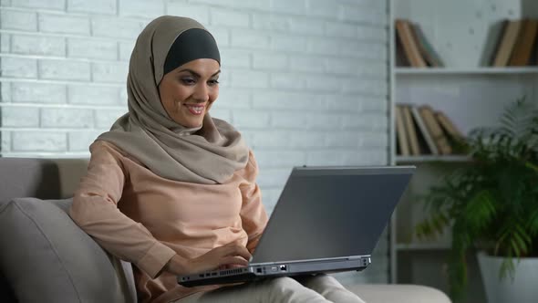 Woman in Traditional Hijab Typing Message on Laptop, Chatting With Friend Online