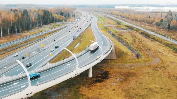 White Truck Rides on the Highway Among the Flow of Cars, Aerial View