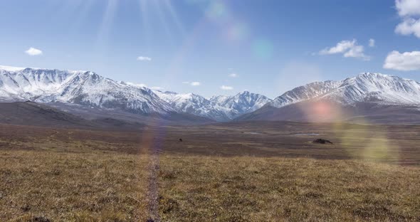 Timelapse of Sun Movement on Crystal Clear Sky with Clouds Over Snow Mountain Top