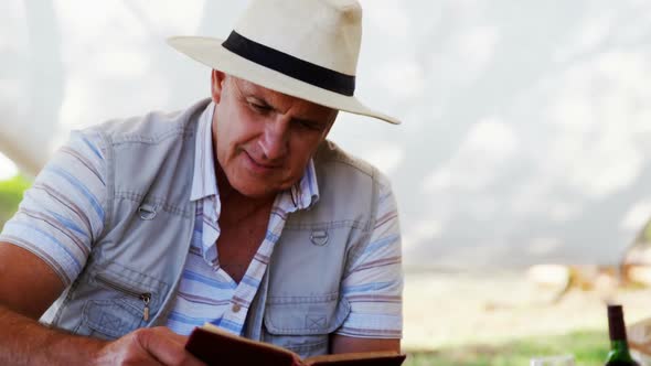 Smiling man reading book in cottage 4k