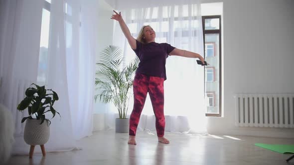 Blonde Happy Overweight Woman Dancing in White Modern Studio