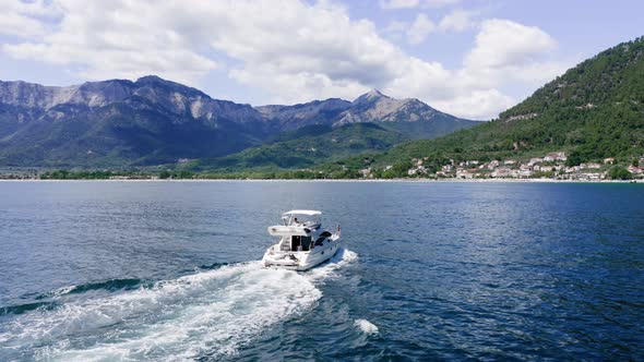 Luxury yacht with family sailing in the sea, drone view, summertime holidays.