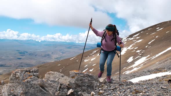 Woman Hiker Climbing on a Peak of a Mountain