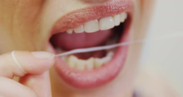 Female patient flossing her teeth