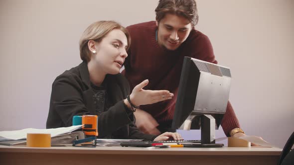 Man  Helping To a Woman Deal with a Computer