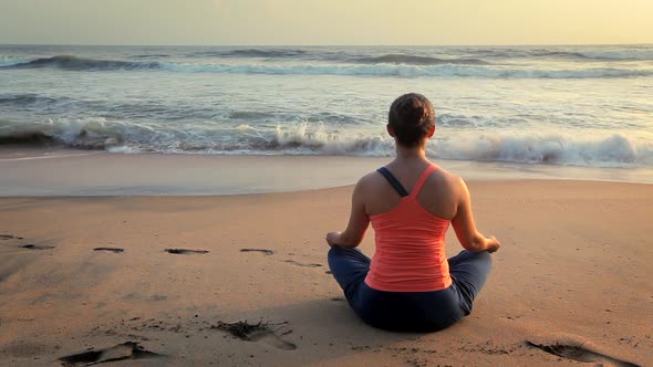 Woman Doing Yoga Oudoors at Beach - Padmasana Lotus Pose