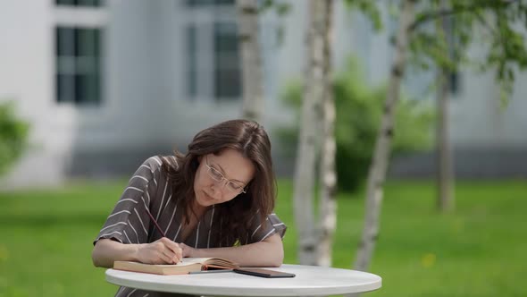 Middleaged Woman is Learning Online Reading Book and Looking for Information in Internet