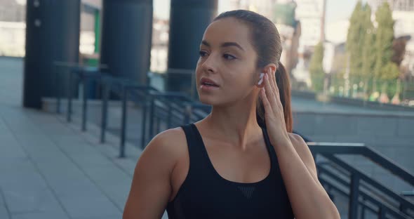 Portrait of Beautiful Young Athletic Woman Wearing Earphones Relaxing After Sport Training Standing