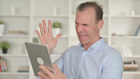 Portrait of Middle Aged Businessman Reacting to Loss on Tablet