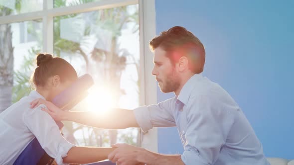 Male physiotherapist giving hand massage to female patient