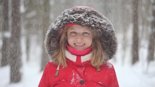 Portrait of a Beautiful Blonde Woman in the Winter Forest with Falling Snow