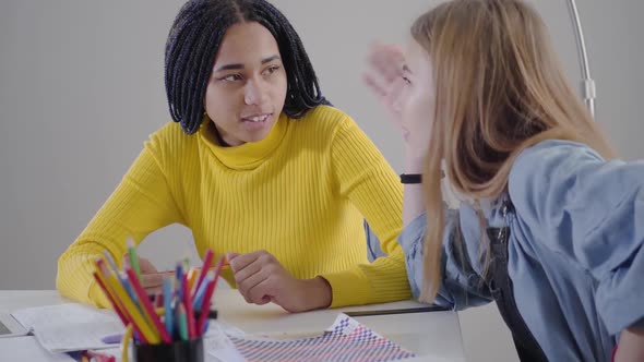 Side View of Caucasian Girl Talking To Her African American Friend and Gesturing Emotionally