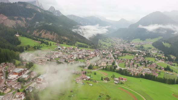 Town on Lush Green Field in Mountain Valley Panoramic View