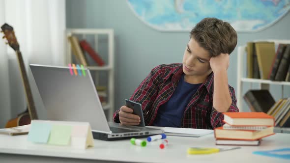 Bored Guy Scrolling Apps on Phone, Distracted From Homework, Procrastination