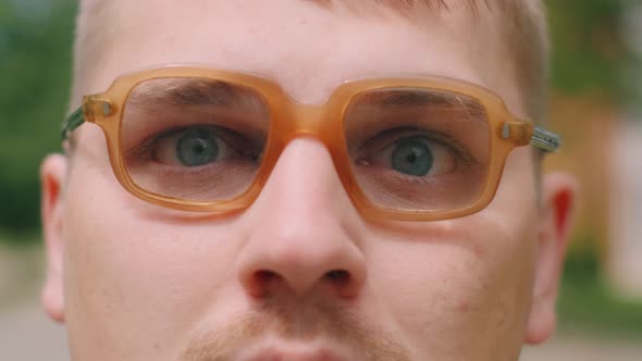 Portrait of Serious Nerdy Man in Glasses. A Loser Teenager Is Looking To the Camera.