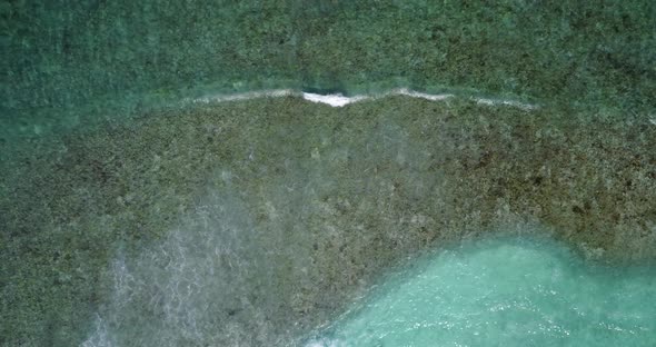 Daytime birds eye island view of a sunshine white sandy paradise beach and blue ocean background in 