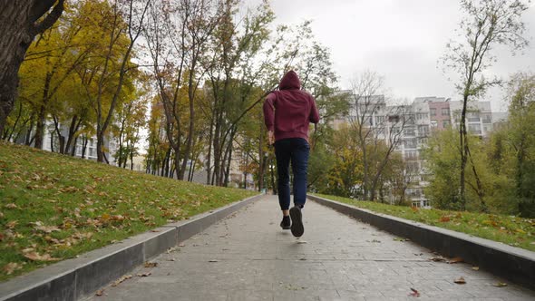 Jogger Exercising in Park in Autumn