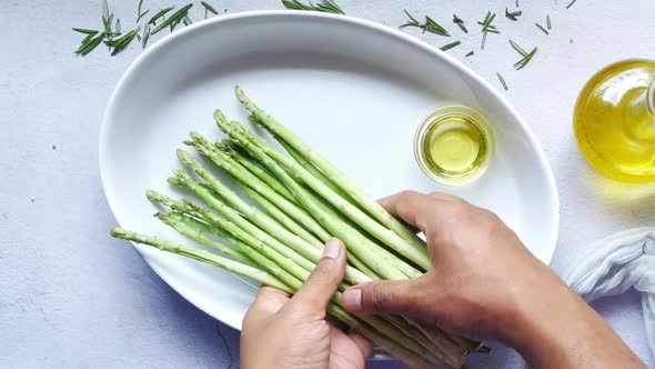 Putting Asparagus Green in a Bowl on Table