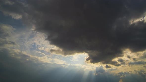 Time lapse footage of fast moving evening clouds on yellow sky at sunset.