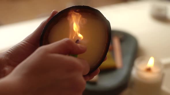 Closeup Hands of Unrecognizable Young Woman Lighting Handmade Aromatic Candle with Lighter in