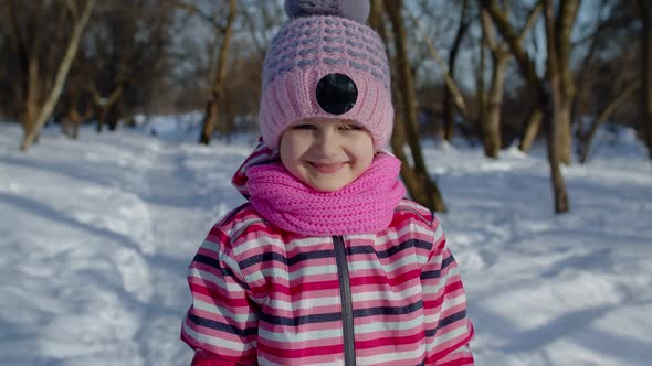 Smiling Child Kid Looking at Camera Showing Tongue Fooling Around Making Faces in Winter Park