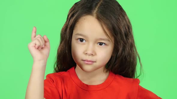 Close-up Child Showing Emotion Punishment on Green Background. Slow Motion