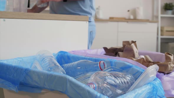 Man Throwing Plastic Bottles into Special Bin