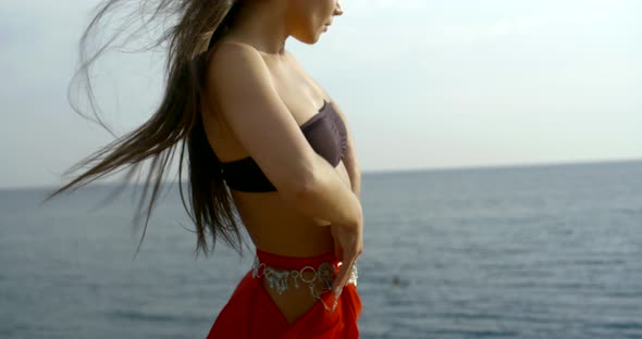 Dancer in Black Top and Long Red Skirt Raises Hands at Sea