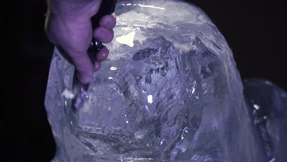 Professional Artist is Carving an Ice Sculpture of a Lion Using a Knife