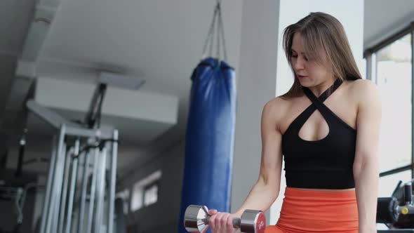 Sports Motivational Video Woman Lifts Dumbbells Trains Arm Muscles in the Gym