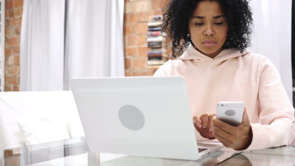 AfroAmerican Woman Browsing Online on Smartphone Typing Message