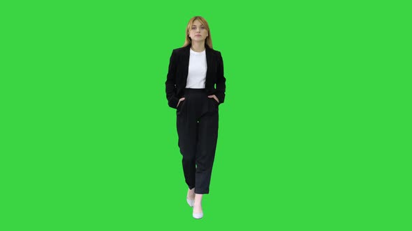 Walking Businesswoman with Hands in Pockets on a Green Screen, Chroma Key.