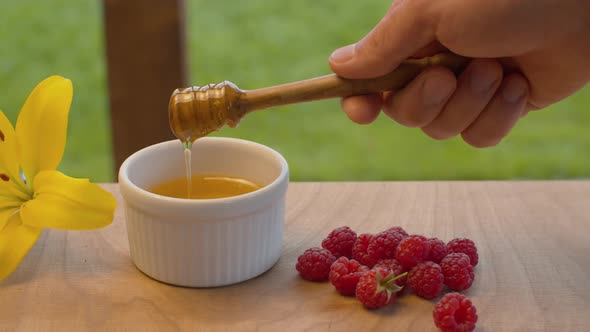 Hand of a man taking honey with honey spoon