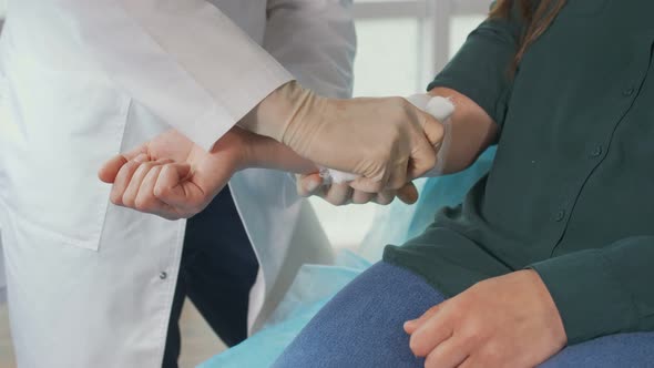 A Physical Therapist Applies a Bandage to a Patient'S Injured Arm