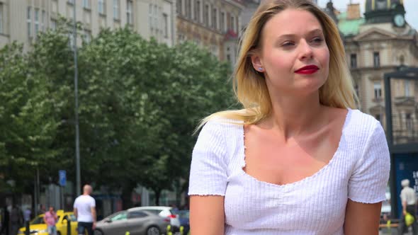 A Young Beautiful Woman Looks Around an Urban Area with a Smile - Closeup