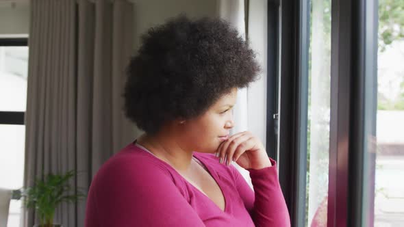 Video of thoughtful plus size african american woman looking outside window