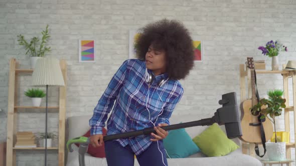 Expressive Positive African American Young Woman Housewife Vacuuming Sings Fun Dancing and Playing