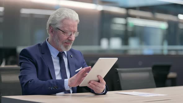 Old Businessman Having Success on Tablet at Work