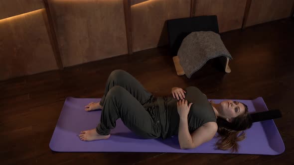 a Woman is Lying on the Floor on a Sports Mat