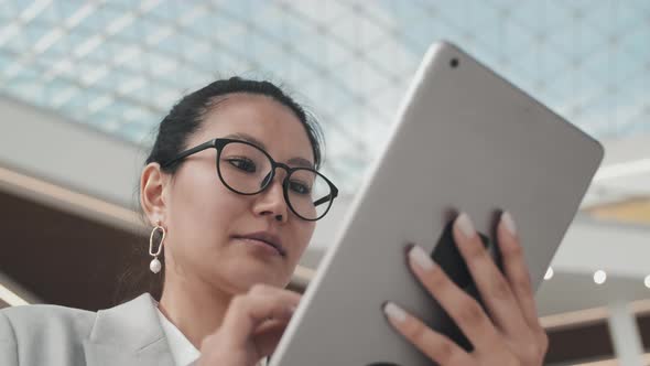 Asian Businesswoman Using Tablet in Lobby