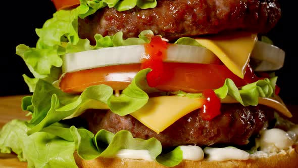 Closeup of Home Made Beef Burgers with Lettuce and Mayonnaise Served on Little Wooden Cutting Board