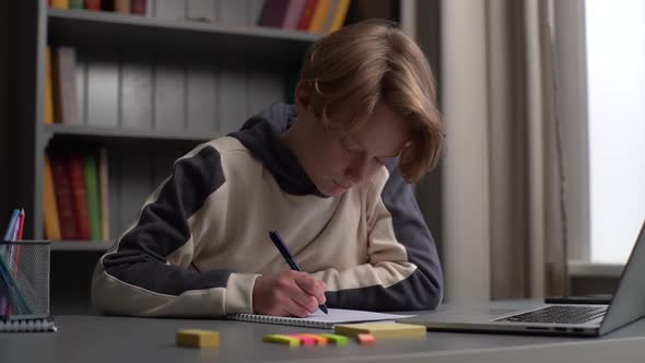 Closeup of Overworked Pupil Boy Doing Homework Taking Notes in Workbook and Falling Asleep