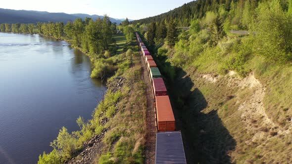 Aerial view of freight train passing by a river