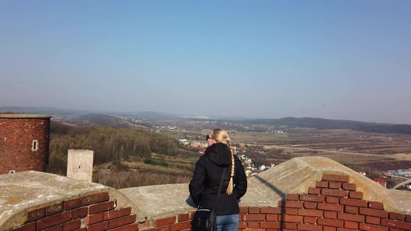 Attractive Female Traveller Looking Around Valley Near the Old Castle