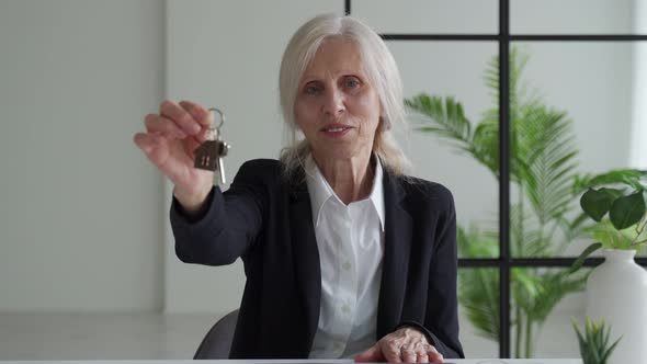 Elderly Woman Real Estate Agent with the Keys to the Apartment in Her Hands