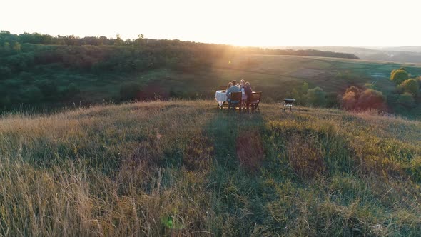 Family Having Lunch at Sunset in Nature